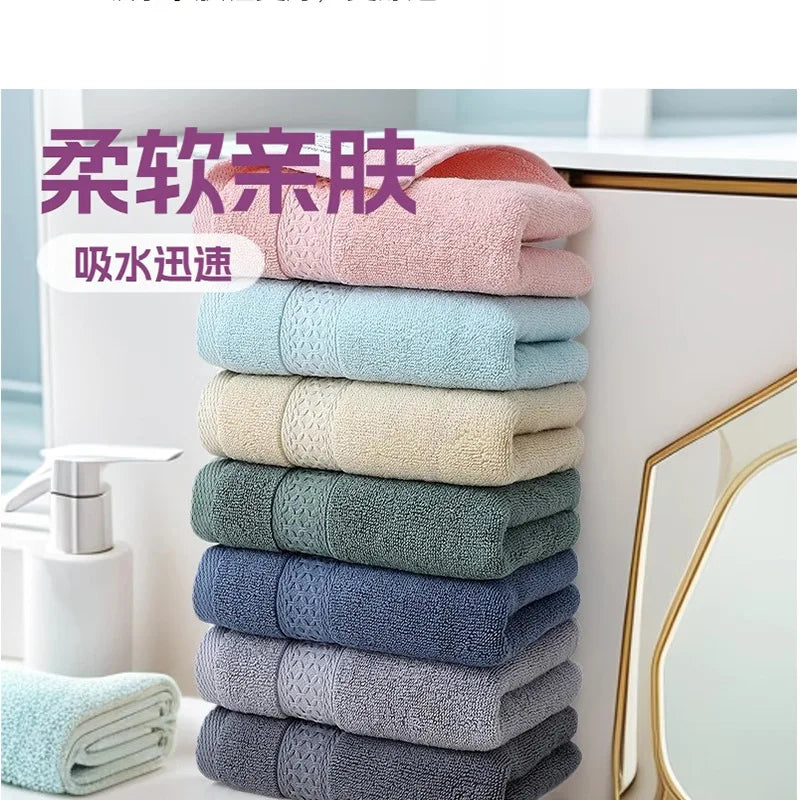 A stack of six pink, blue, and gray premium pure cotton face towels displayed next to a mirror.