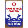 A vintage metal tin sign with a distressed look featuring text that reads Swim at your own risk and Lifeguard on beer break.