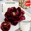 A deep burgundy lotus flower silicone mold resting on a white surface with loose silicone strands nearby.