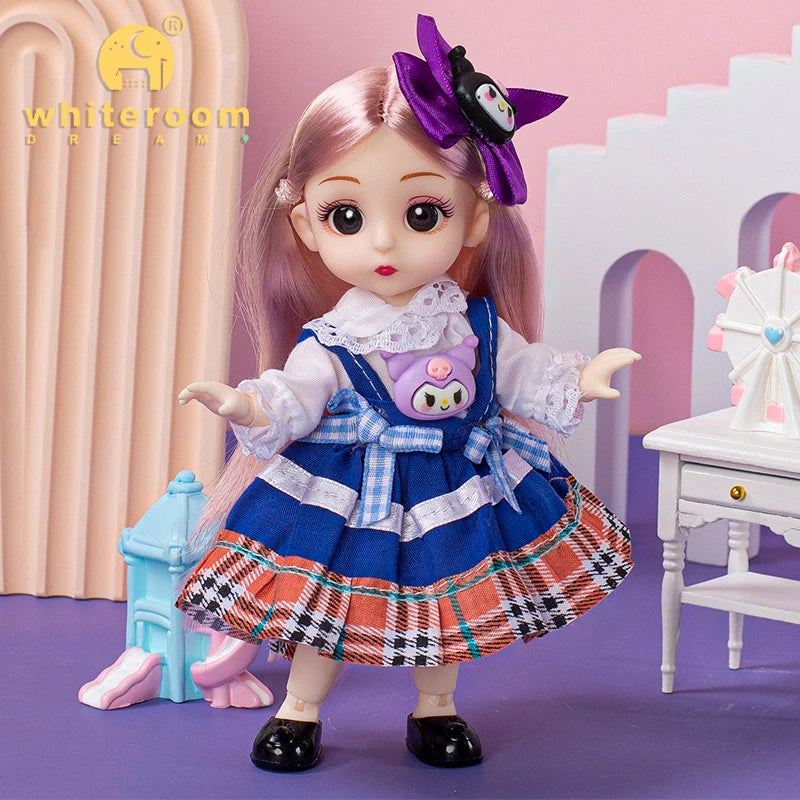 A pink-haired fashion doll wearing a blue and orange plaid dress and white collar, standing in front of a light pink backgrou