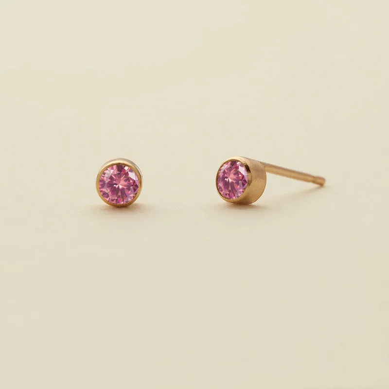 Boucles d'oreilles à clous minimalistes en or, avec un gemme rose.