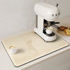 A white espresso machine is placed on a light beige quick-dry diatom mud absorbent counter mat.