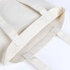 A light beige reusable canvas shopping tote bag with a foldable design shown from above.