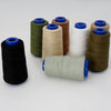 A collection of spools of heavy-duty polyester thread in various colors including olive green, beige, white, and brown.
