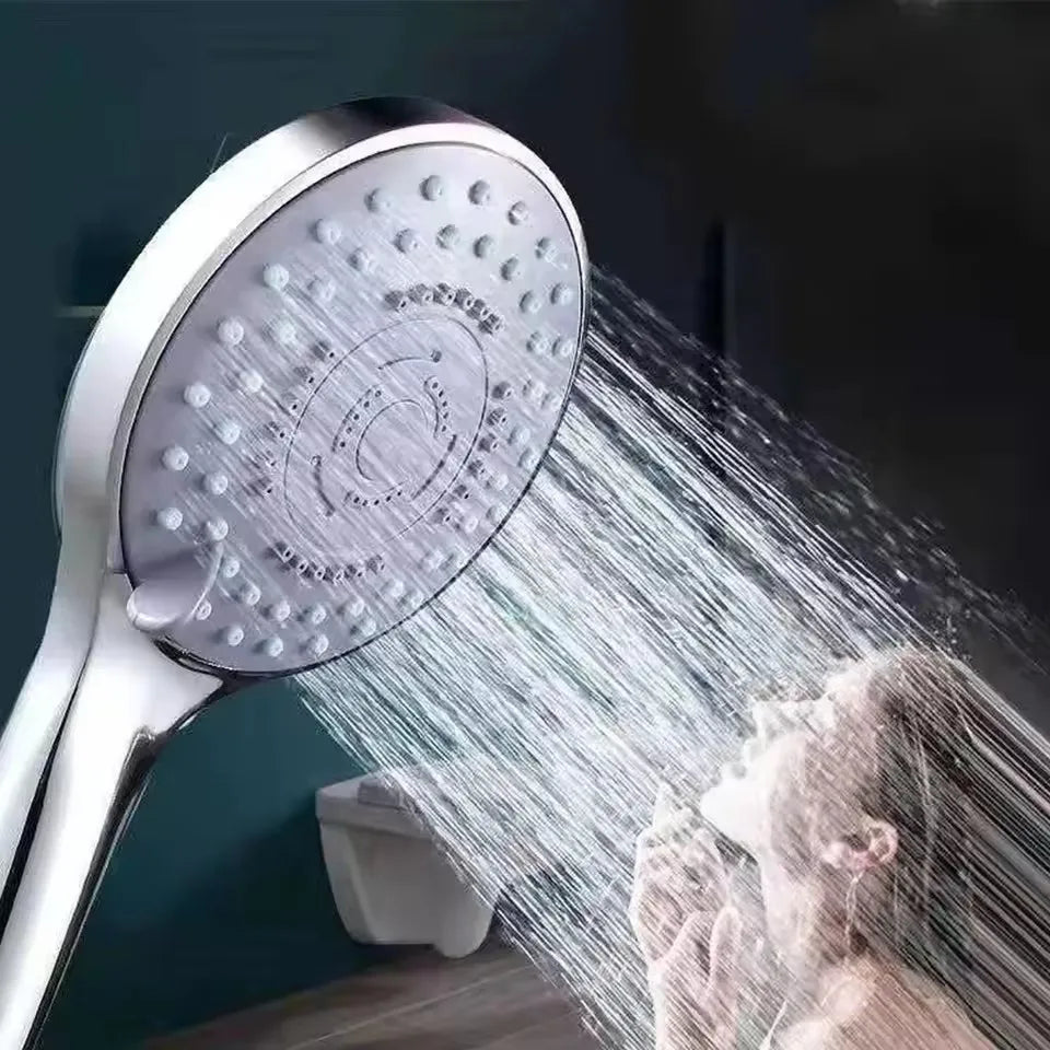 Eine Hochdruck-Handduschdüse sprüht einen starken Wasserstrahl auf die Haare einer Person.