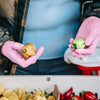 Pink nitrile gloves holding a green bell pepper in a kitchen setting