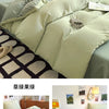 A set of four ultra-soft washed cotton duvet covers in a pale sage green color displayed on a bed.