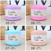 Eight skeins of cotton yarn in various colors including purple, pink, and blue, displayed next to woven baskets.