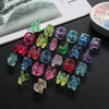 A collection of colorful acrylic alphabet beads in various shades and shapes arranged on a dark surface.