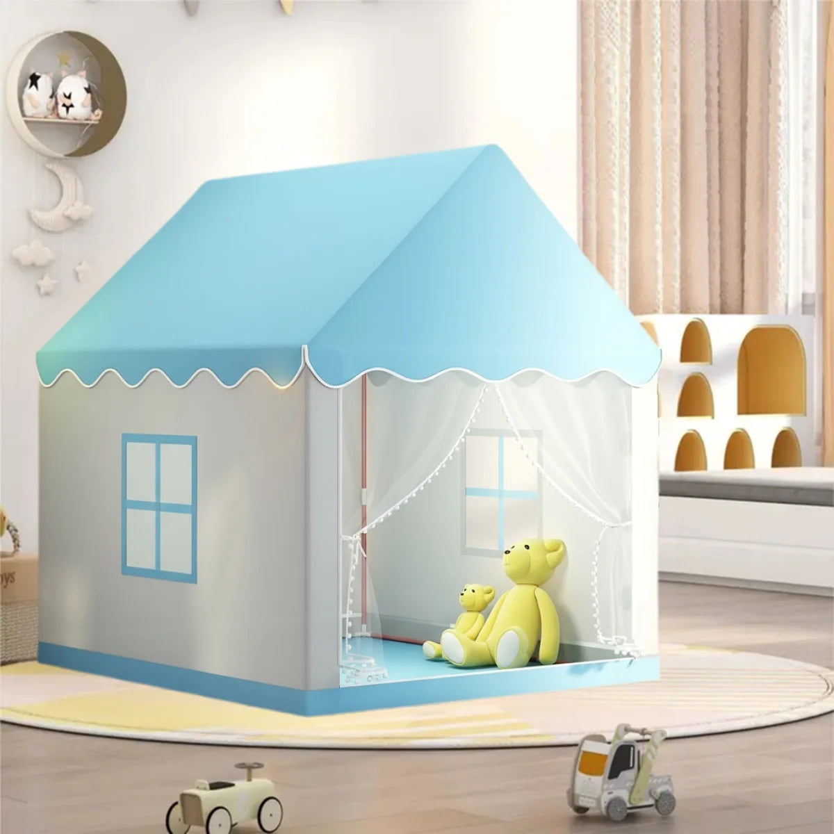 A light blue play tent shaped like a house with a pitched roof and decorative trim, featuring a window and yellow stuffed ani