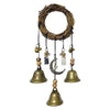 A rustic wreath made of twigs with several hanging brass bells and charms.