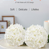 White silk hydrangea flowers with a 3D design displayed on a white platter.