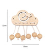 A wooden Montessori busy board accessory kit featuring a cloud shape and hanging round wooden pieces.