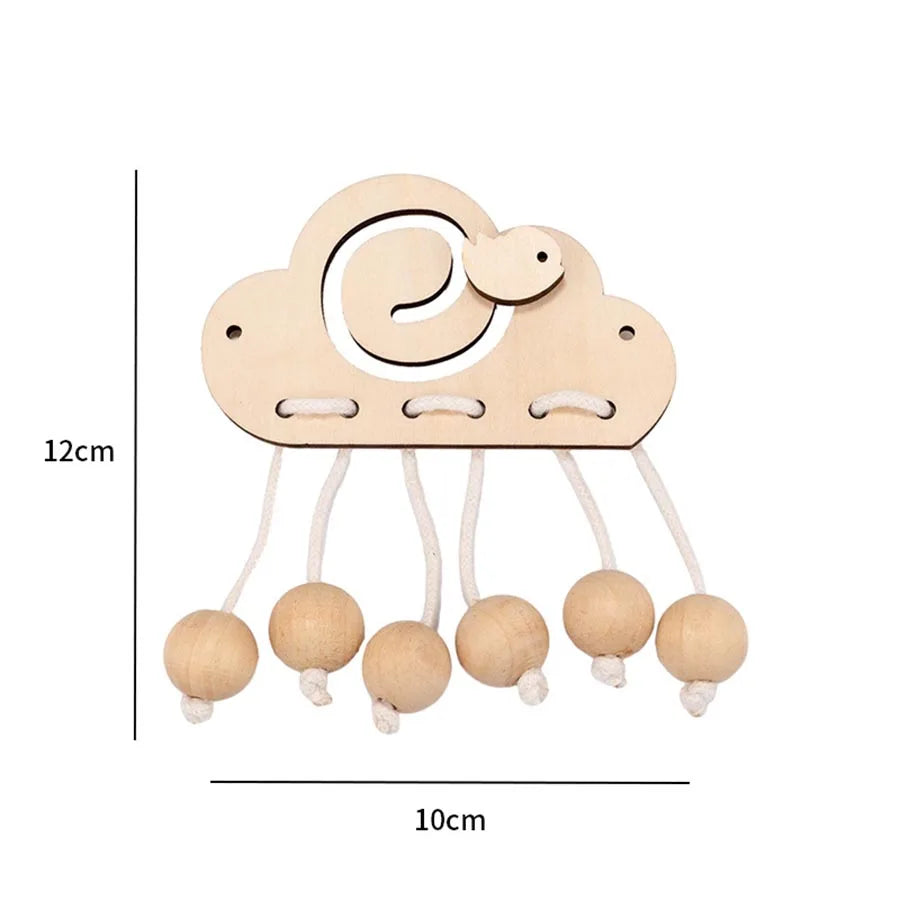 A wooden Montessori busy board accessory kit featuring a cloud shape and hanging round wooden pieces.
