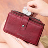 Une main tient un porte-monnaie plié en cuir marron anti-RFID avec une fermeture éclair argentée et une étiquette métallique.