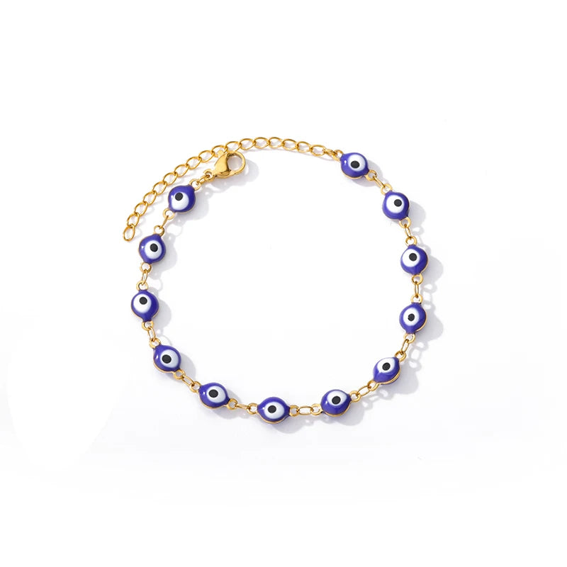 Goldene Armbandkette mit kleinen blauen und weißen Schutzaugen-Anhängern.
