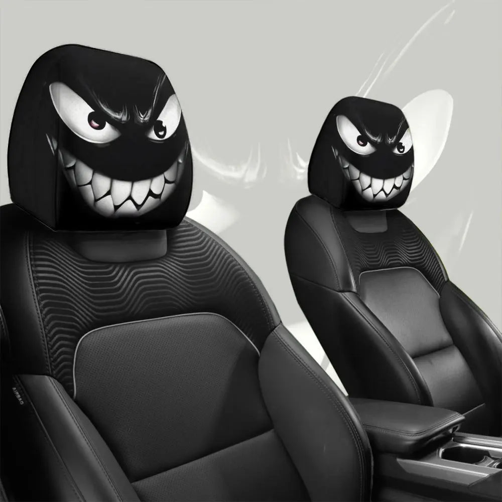 A pair of black car headrest covers featuring menacing, grinning monster faces.