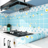 A kitchen splashback featuring blue and white floral tiles and a stainless steel hood with a roll of self-adhesive wallpaper.