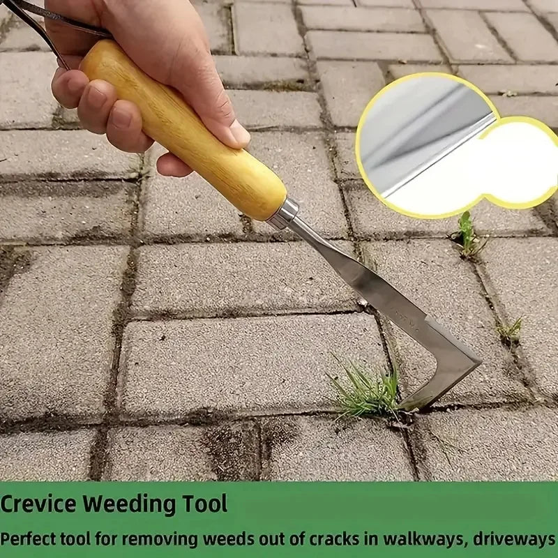 A hand holds an L-shaped stainless steel weeding tool with a wooden handle, used for removing weeds from cracks in walkways.