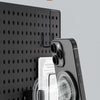 A magnetic suction phone stand holding a smartphone against a dark textured surface.