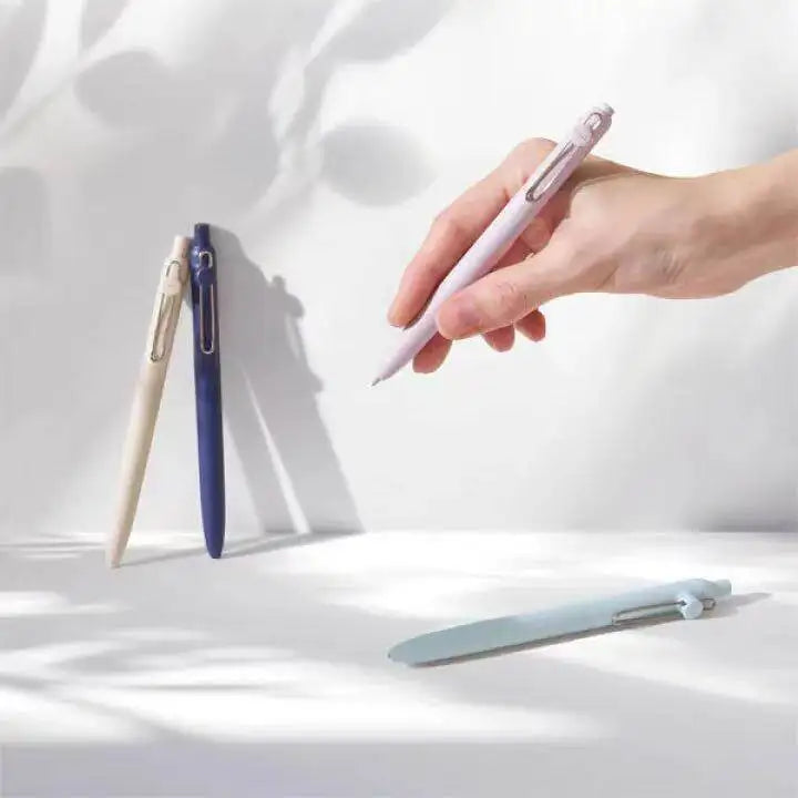 A hand holds a pink Uni ZENTO Quick-Dry Gel Pen against a white background.