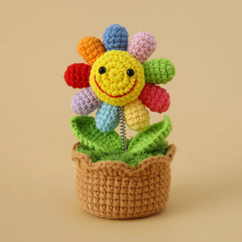 Handcrafted crochet sunflower with colorful petals growing in a brown pot