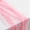 Pink faux pearl tulle table runner draped elegantly on a white surface.