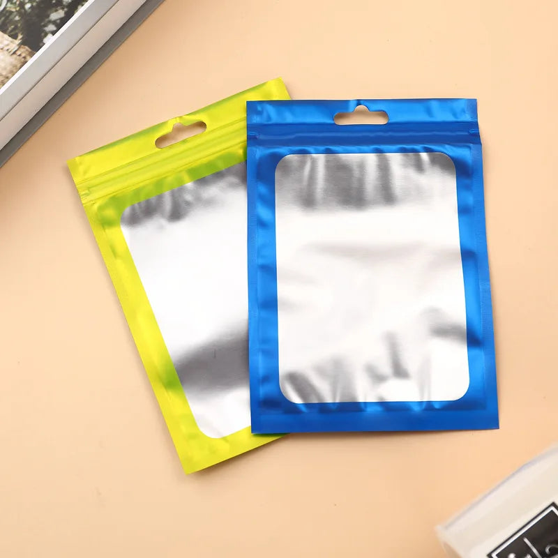 Two colorful Mylar ziplock bags, one yellow and one blue, with clear windows for packaging small items.