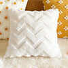White chevron textured decorative pillow cover resting on a fluffy white rug next to yellow and brown pillows.