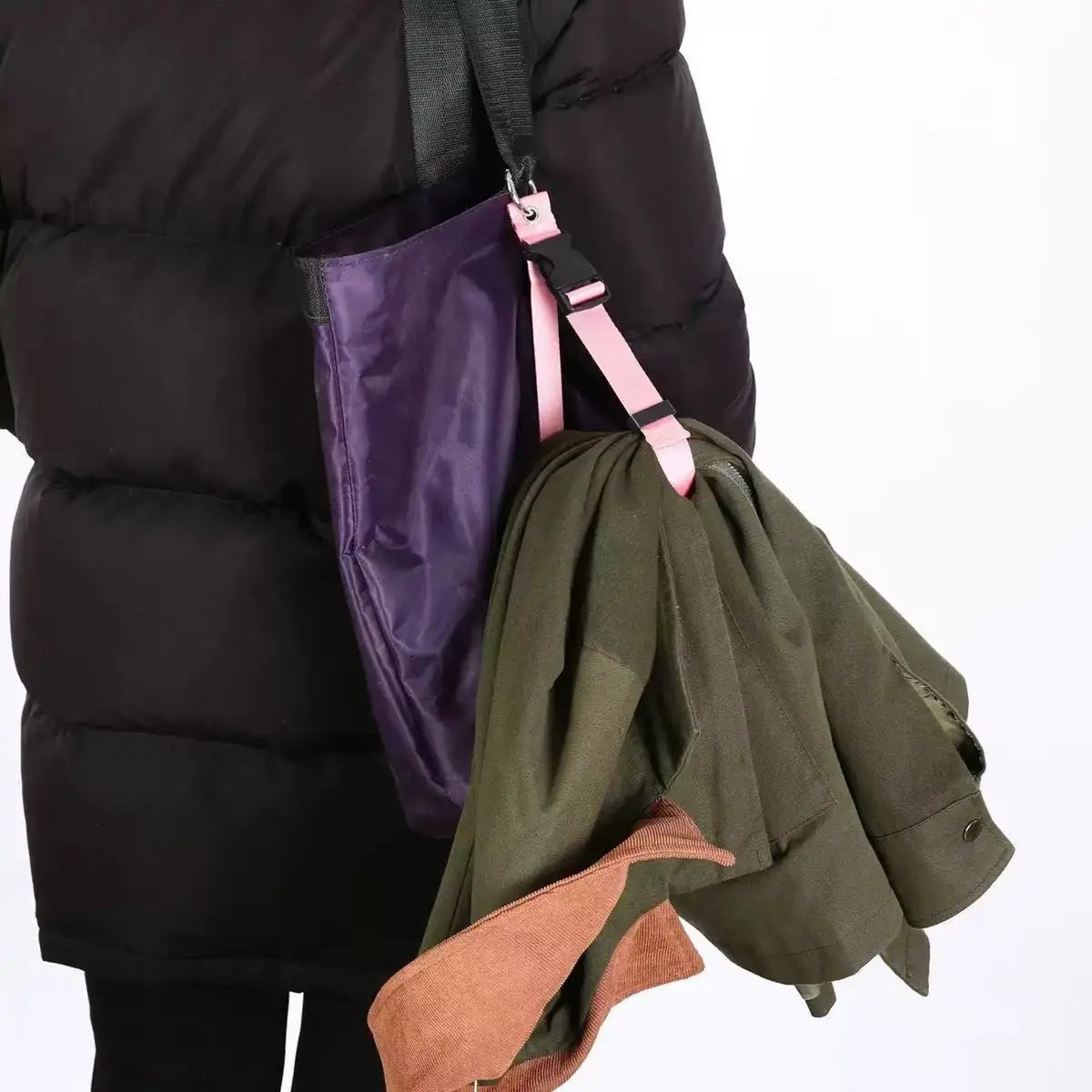 A dark green travel luggage strap and belt is visible attached to a black puffer jacket.