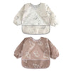 A pair of white and beige waterproof long-sleeve baby bibs with a subtle animal print pattern.