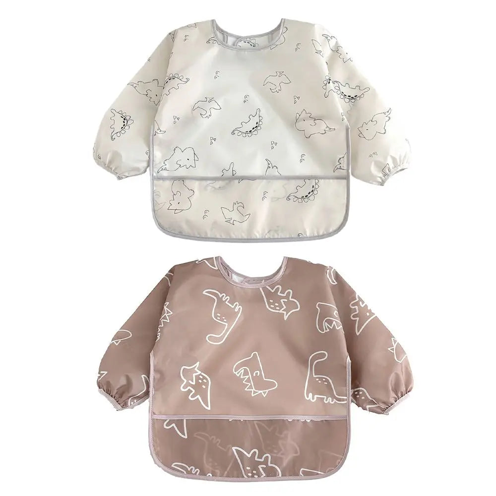 A pair of white and beige waterproof long-sleeve baby bibs with a subtle animal print pattern.