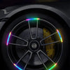 Colorful reflective warning stickers applied to a car wheel hub for night safety and style