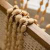 Close-up of a wooden railing decorated with beige tassels and lanterns.
