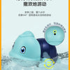 A light blue cartoon turtle bath toy is shown floating in water, with surrounding splashing.
