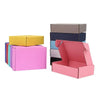 Eine Sammlung farbenfroher Wellkartons in verschiedenen Schattierungen, darunter Gelb, Pink, Blau und Grau.