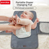 A baby is being changed on a portable diaper changing pad with a waterproof cover and storage bag.