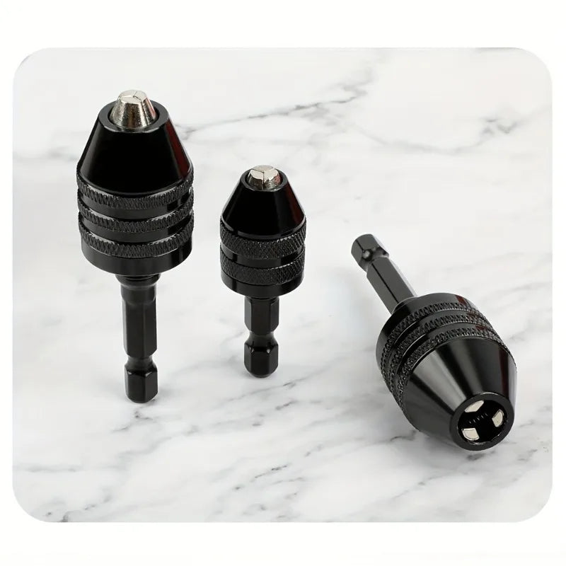 Three black quick-change hex shank drill chucks with round handles displayed on a white marble surface.
