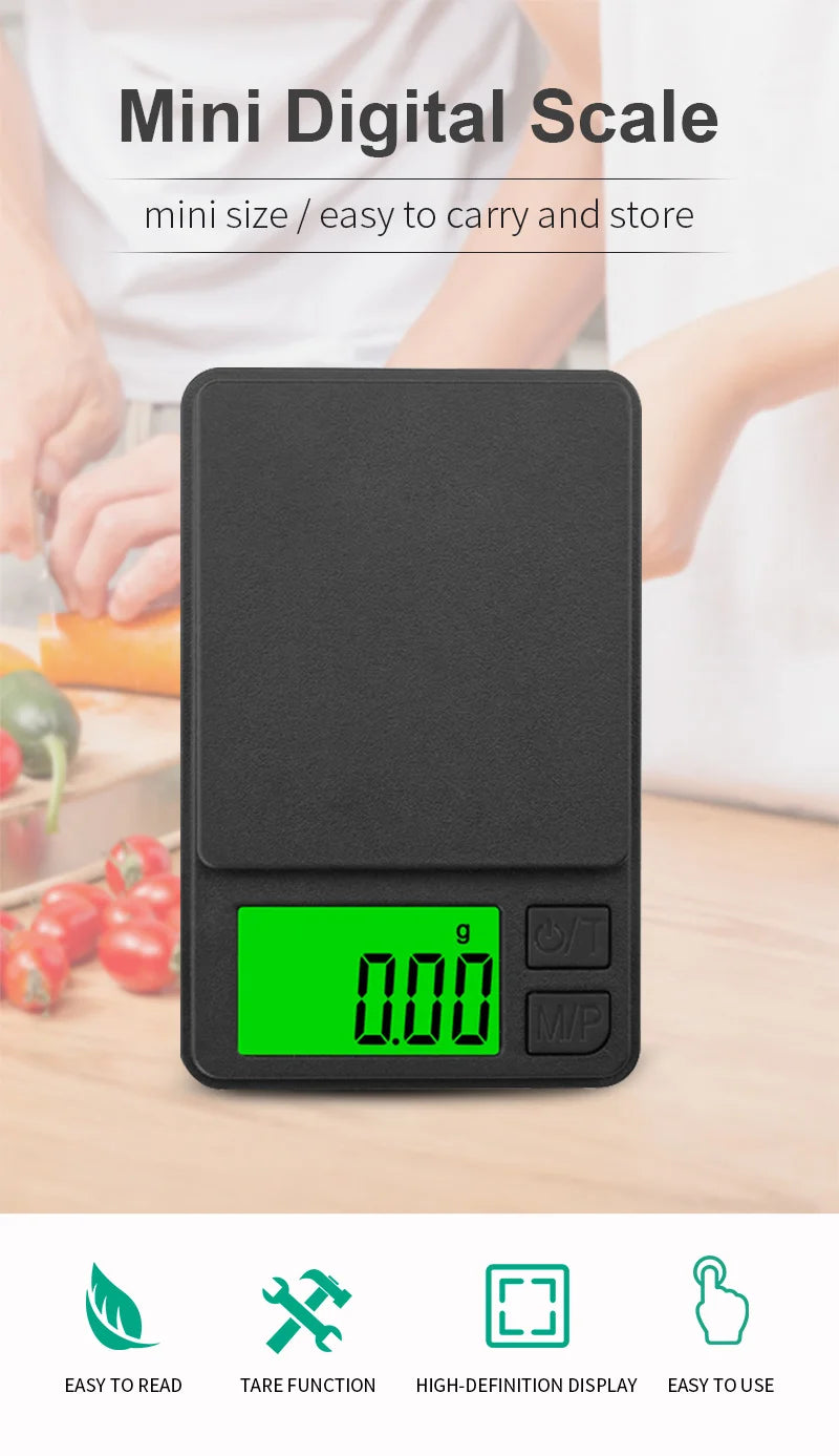 A black mini digital scale with a green display showing 0.00, shown against a blurred background of fresh produce.