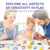 Un père et une mère peignent un enfant avec un kit DIY d'espace et de dinosaures sur une table.