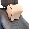 A beige memory foam car headrest pillow with a black trim is shown in a brown leather seat.