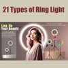 A woman is positioned in front of a glowing ring light setup with various colored lights and tripods for video streaming.