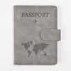 A gray leather passport holder with the word PASSPORT and a world map design.