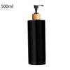 A black and wooden refillable shampoo and lotion dispenser bottle with a pump top.