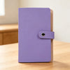 A purple 100-slot cash organizer binder with a snap closure and a light brown cover, resting on a wooden surface.
