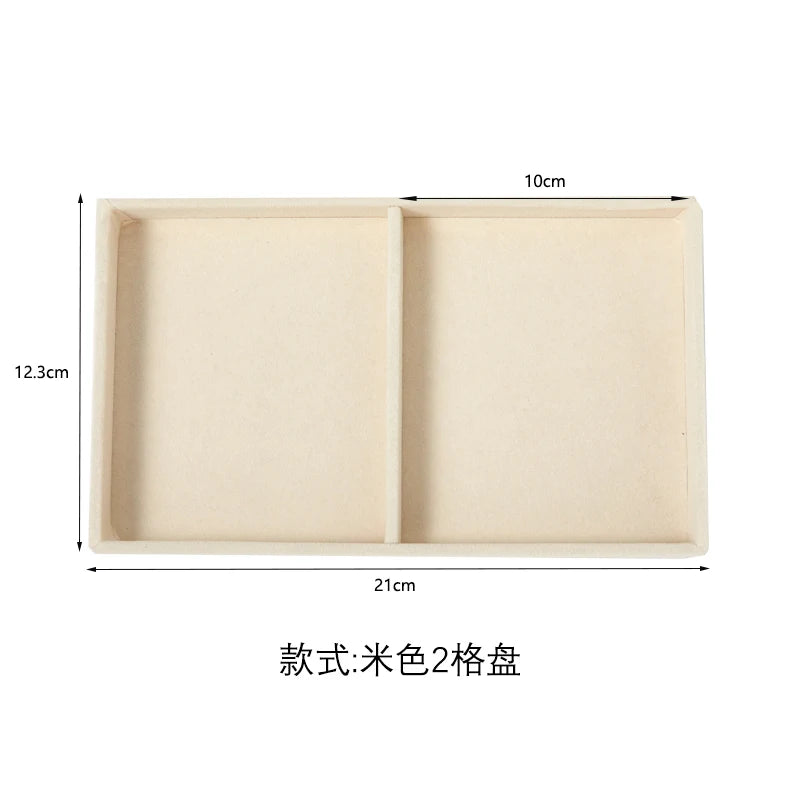 A light beige velvet jewelry organizer tray with two detachable compartments.