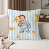 A decorative pillow featuring a cartoon illustration of George and a monkey surrounded by yellow stars on a blue and white st