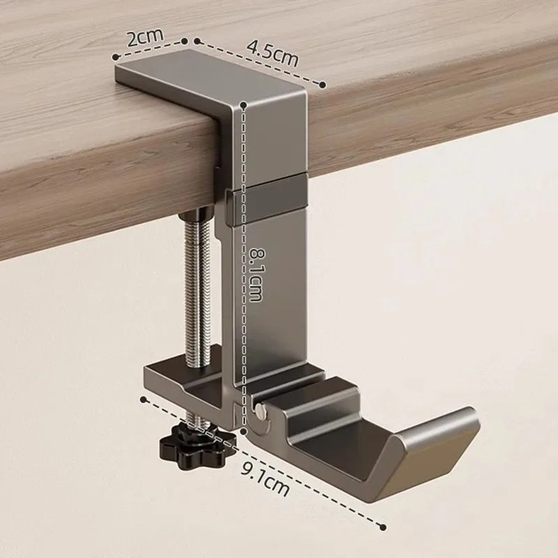 A close-up view of a foldable aluminum desk hook with various dimensions shown against a wooden surface.