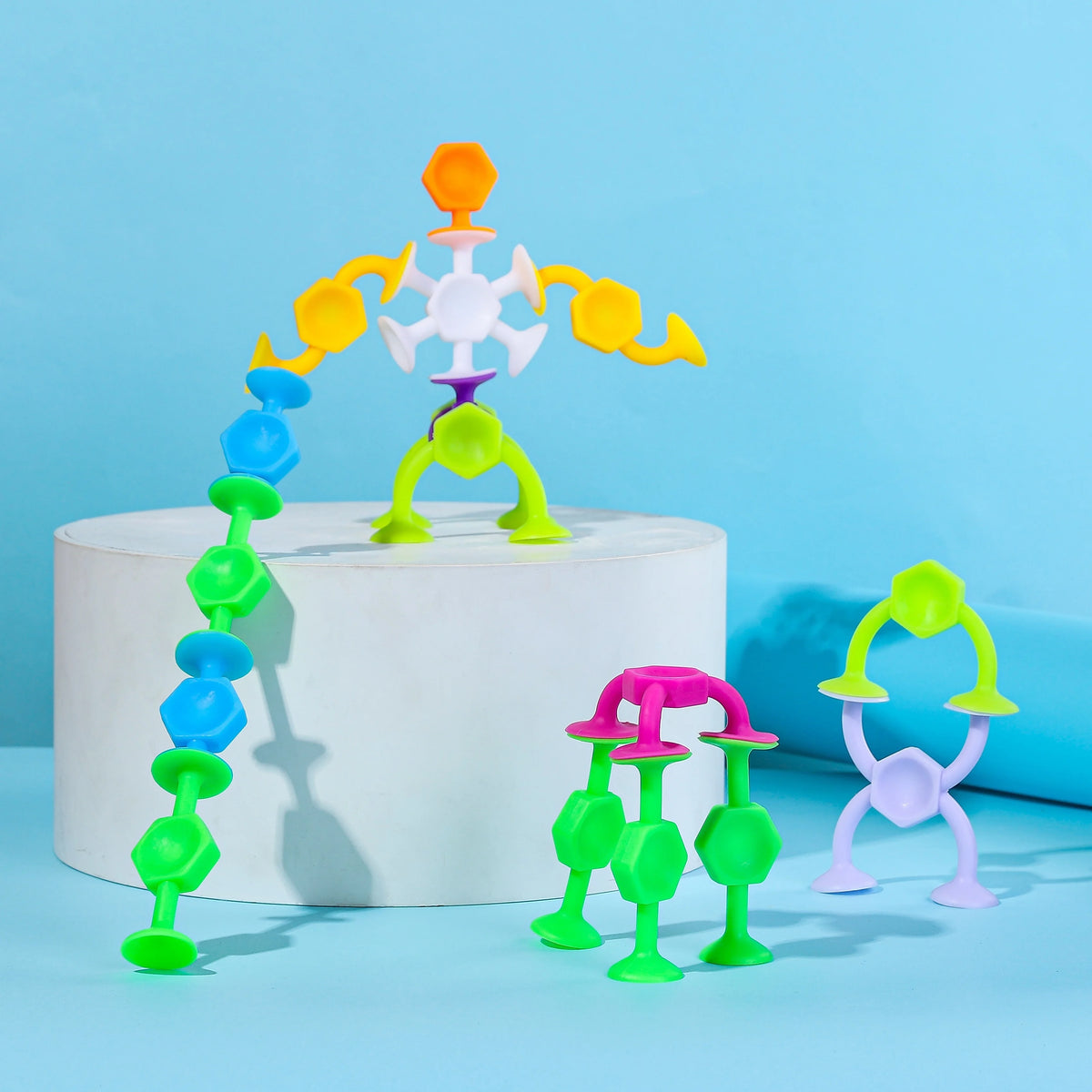 Colorful silicone suction bath toys shaped like molecules and atoms displayed on a white stand.