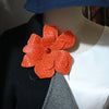 Orange crystal rhinestone flower sew-on patch sewn onto a black garment.